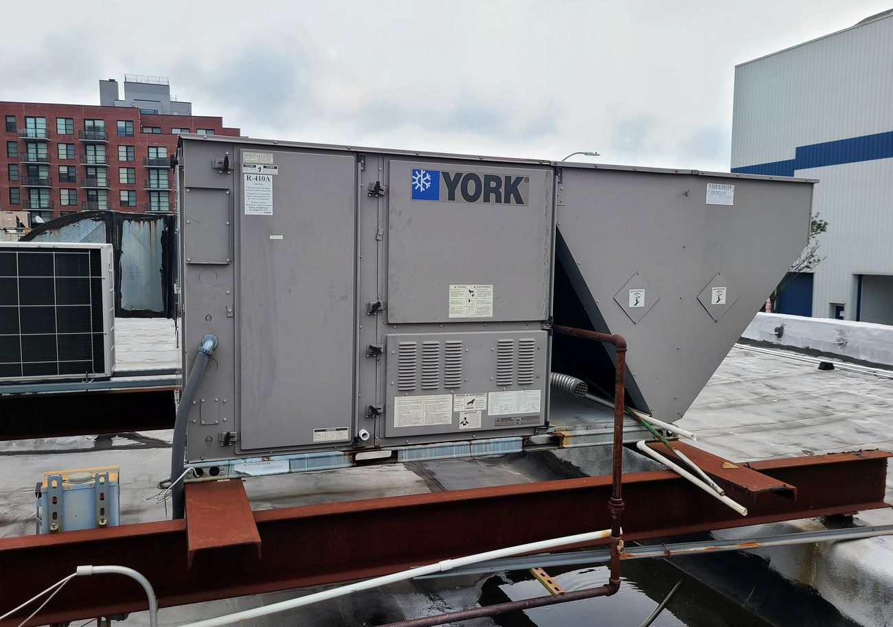 A York rooftop packaged unit with its duct drop on a Brooklyn roof